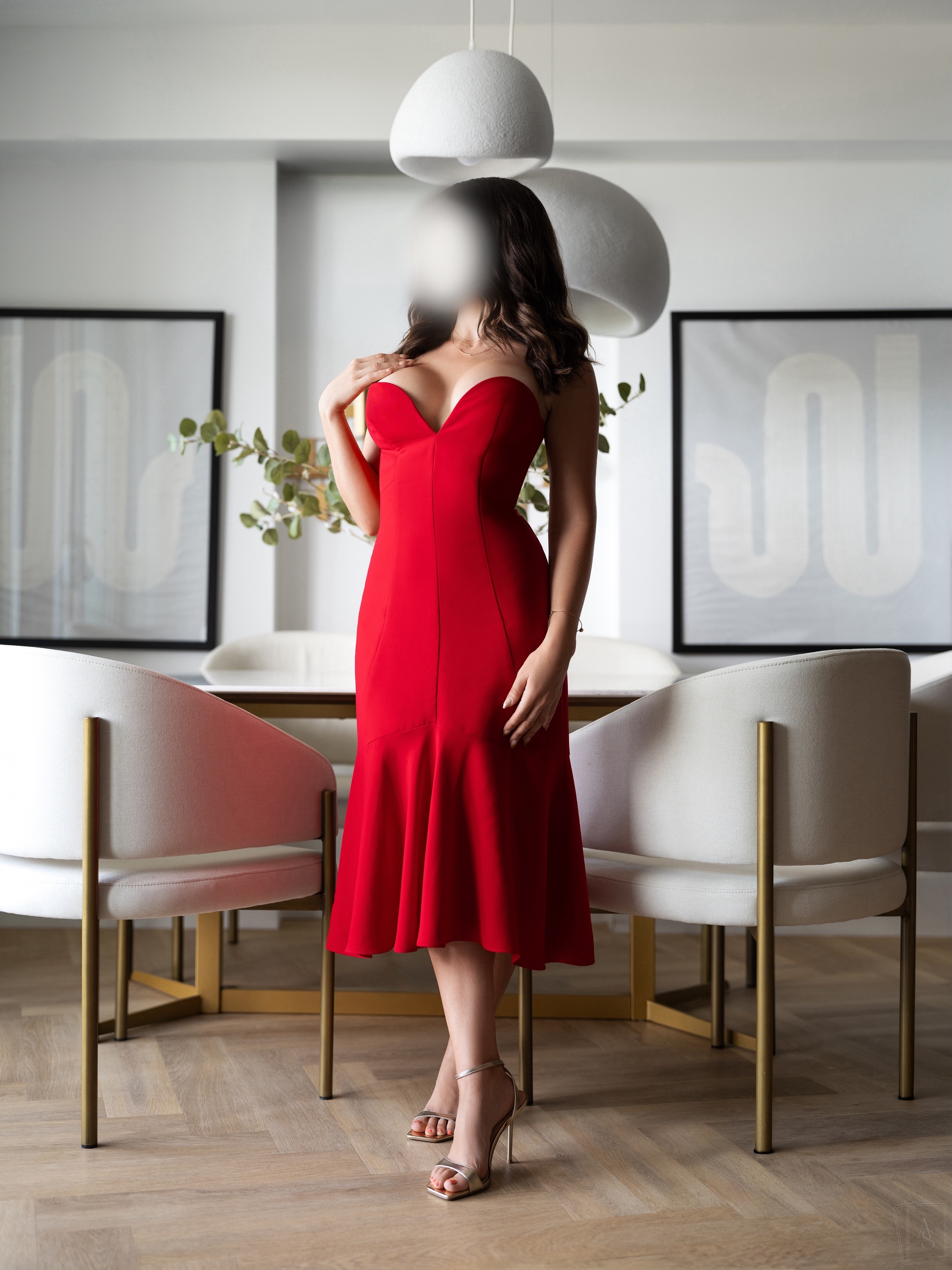 Woman in a red dress standing in a bright dining room