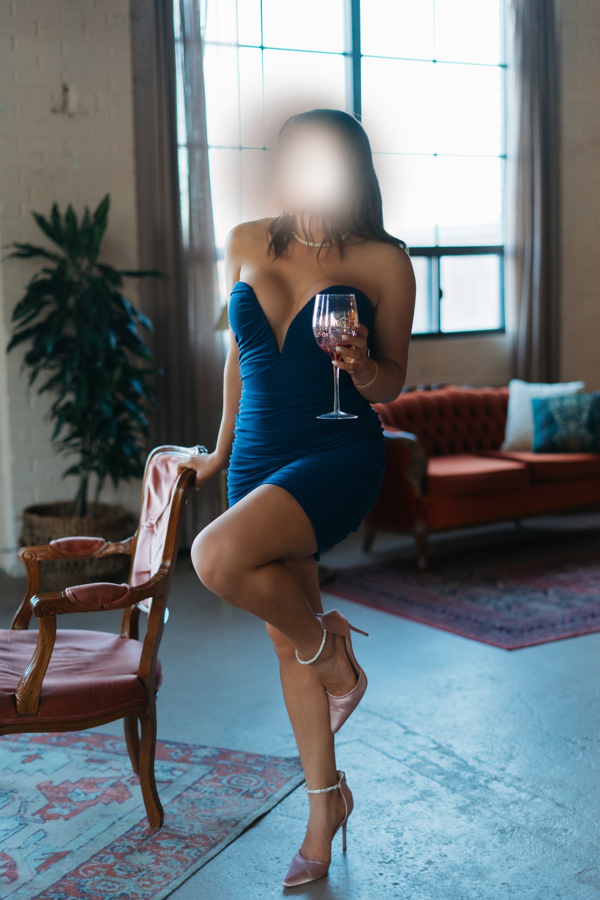 Standing in a blue dress with a glass of wine